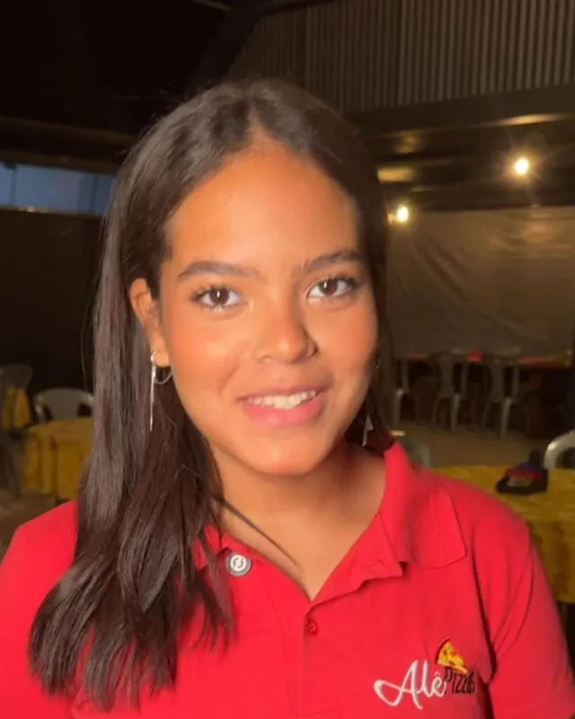 Atendente da Alê Pizzas de uniforme vermelho