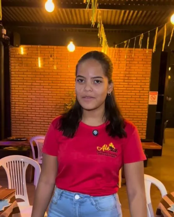 Atendente da Alê Pizzas no salão de tijolinhos